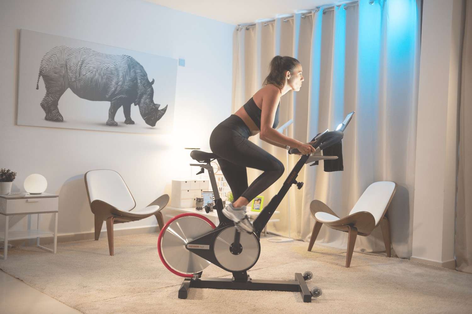 Woman at home riding on her indoor bike. 